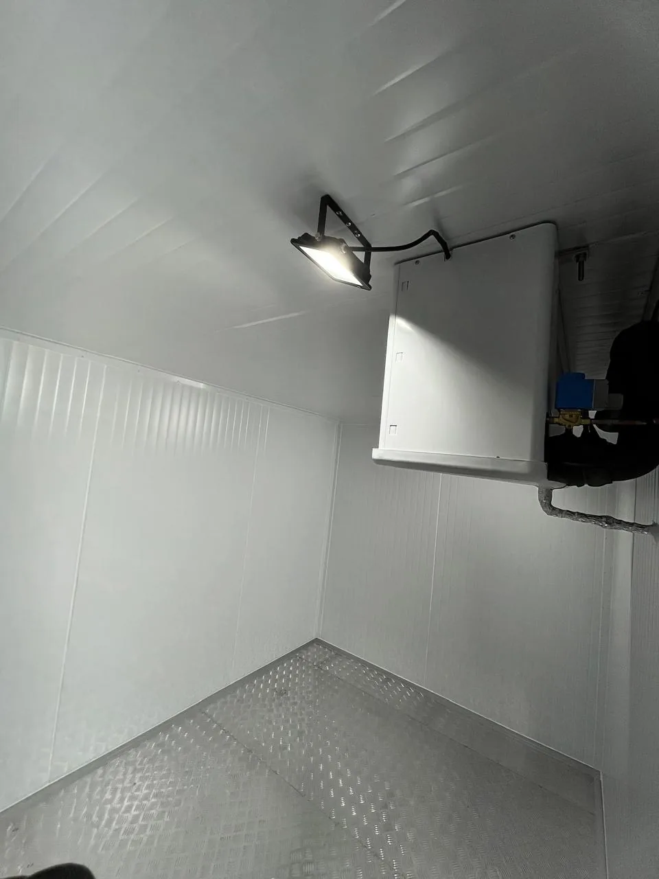 Evaporador con válvula solenoide y cañerías en el interior de una cámara con piso de aluminio