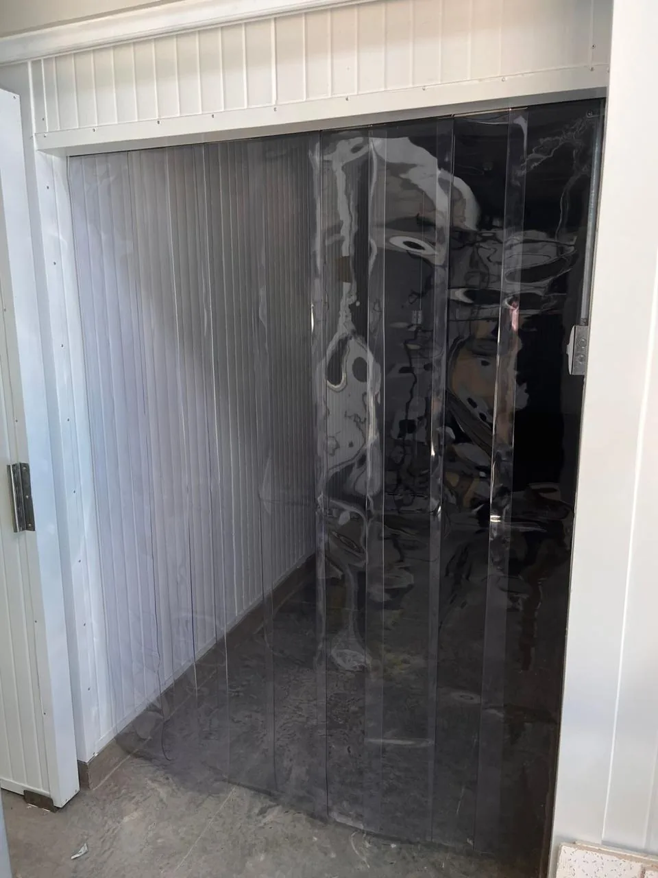 Cortina de lamas de PVC ahumada en el acceso a una cámara frigorífica